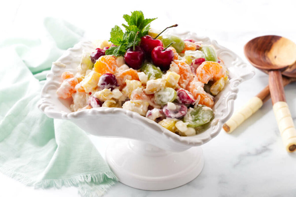 Three red cherries on top of a serving of ambrosia coconut salad.