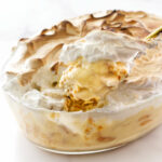 Traditional banana pudding topped with meringue in a glass dish.