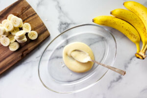 Adding vanilla pudding to a dish for a layered dessert of nanner pudding.