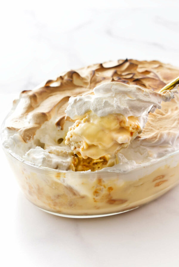 A spoon scooping some classic banana pudding with meringue.