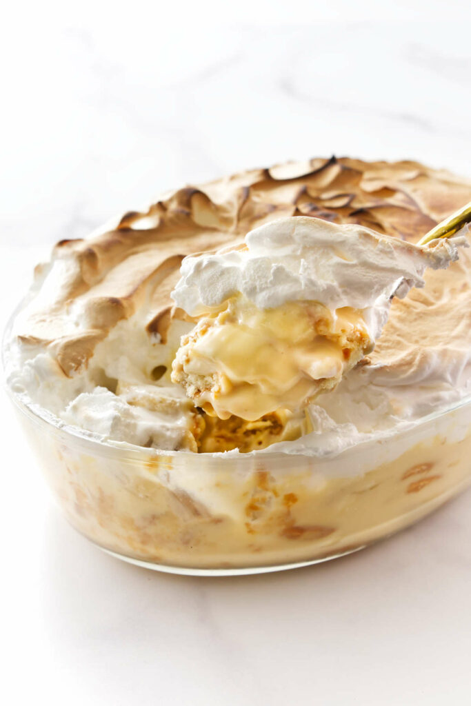 A spoon scooping some classic banana pudding with meringue.