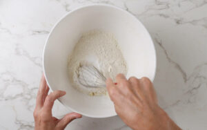 Whisking dry ingredients in a bowl.