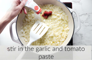 Adding garlic and tomato paste to the skillet.