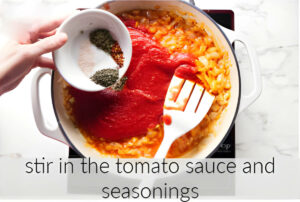 Stirring in the tomato sauce and seasonings.