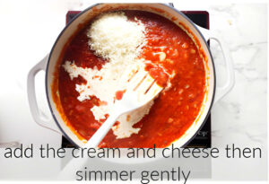 Adding cream and cheese to the tomato sauce.