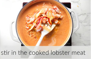 Stirring in the lobster meat into the tomato sauce.