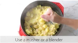 Using a potato masher to mash baby potatoes.