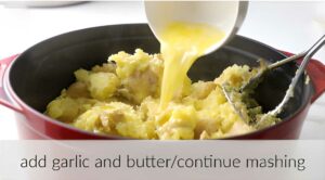 Adding garlic and melted butter to a pot of mashed potatoes.