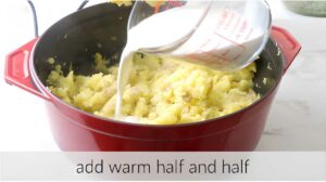 Pouring warm milk into mashed creamer potatoes.