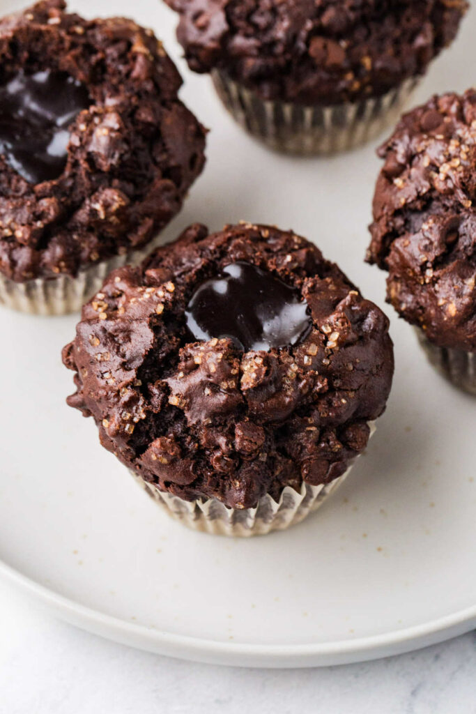 Several fudge filled molten chocolate muffins on a plate.