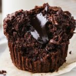 A molten chocolate muffins with fudge in the center.