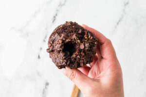 Creating a hole in the center of a chocolate muffin to add filling.
