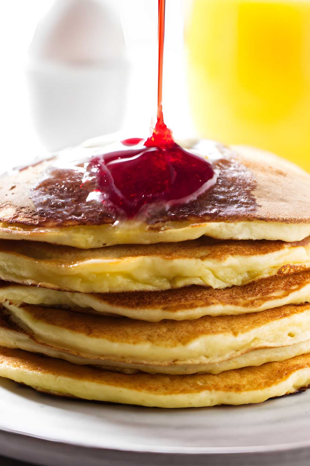 Pouring syrup over ricotta pancakes.