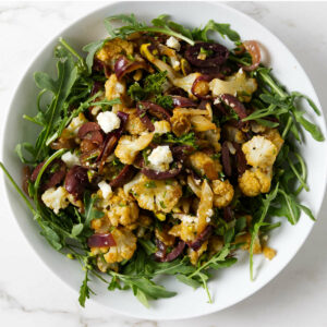 Salad with arugula, roasted cauliflower, olives, red onions, and feta.