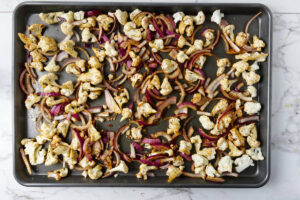 Roasted cauliflower and onions on a sheet pan.