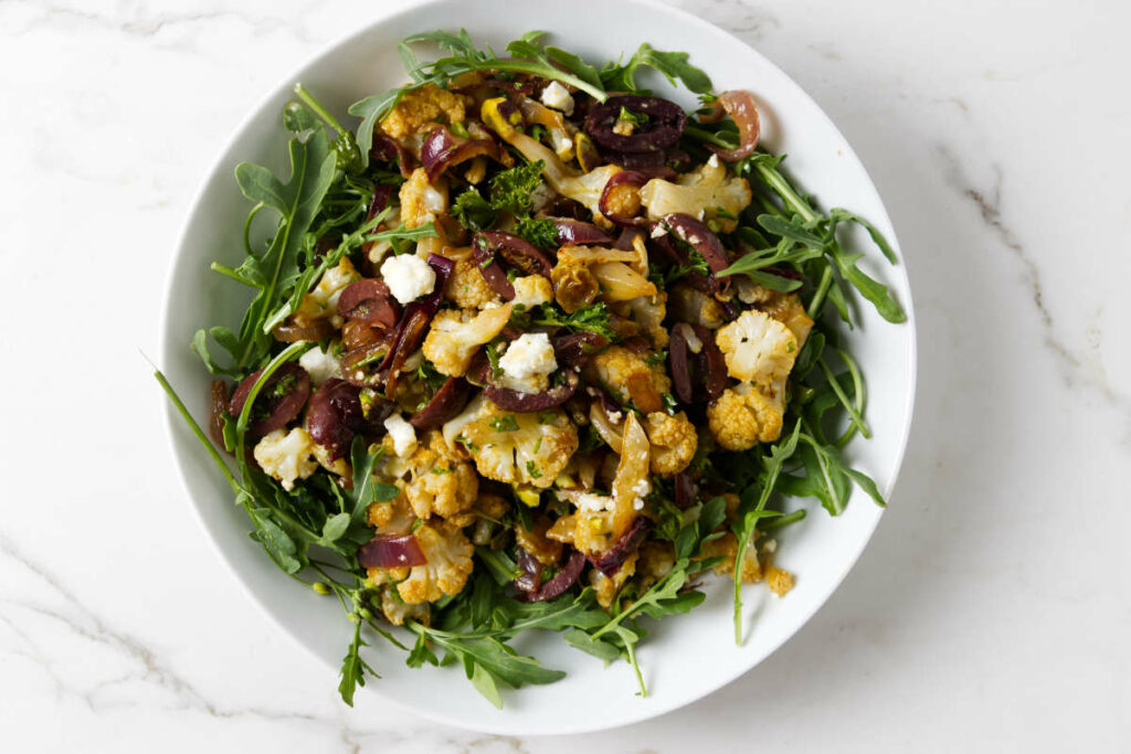 A roasted cauliflower salad tossed with arugula.