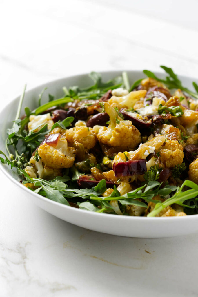 A large salad bowl filled with roasted cauliflower salad.