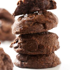 Four sourdough chocolate cookies on a white counter.