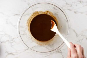 Melting chocolate with warm brown butter in a bowl.