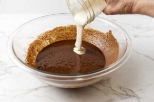 Pouring sourdough discard into cookie batter.