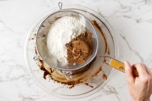 sifting dry ingredients into the sourdough cookie dough.