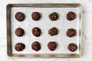 Freshly baked fudgy cookies on a sheet pan.