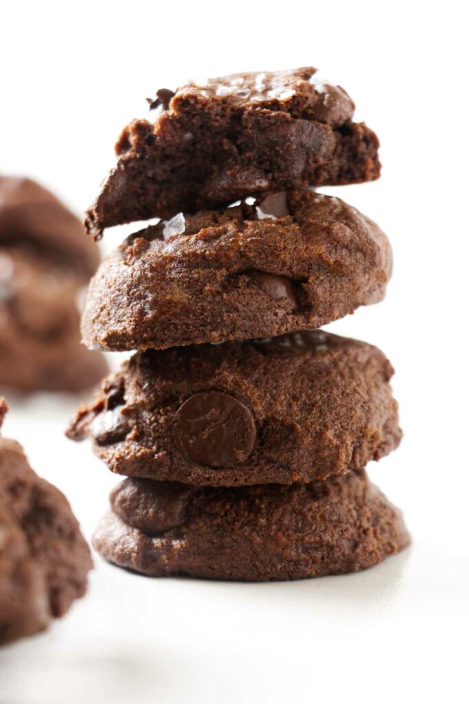 A stack of four sourdough chocolate cookies on a white counter.
