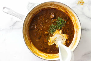 Adding cream to the diane sauce.