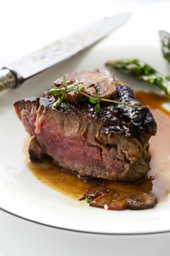 A pan-seared steak with creamy brandy sauce and mushrooms.