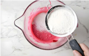 Sifting flour into cake batter.