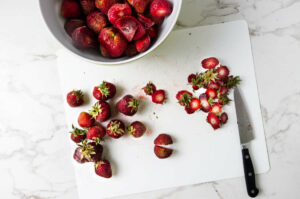 Slicing the top off fresh strawberries.