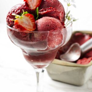 Homemade sorbet made with strawberries in a pretty glass.