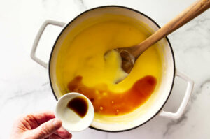 Adding vanilla extract to homemade pudding.