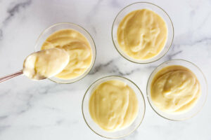 Spooning pudding into glasses after showing how to make vanilla pudding.