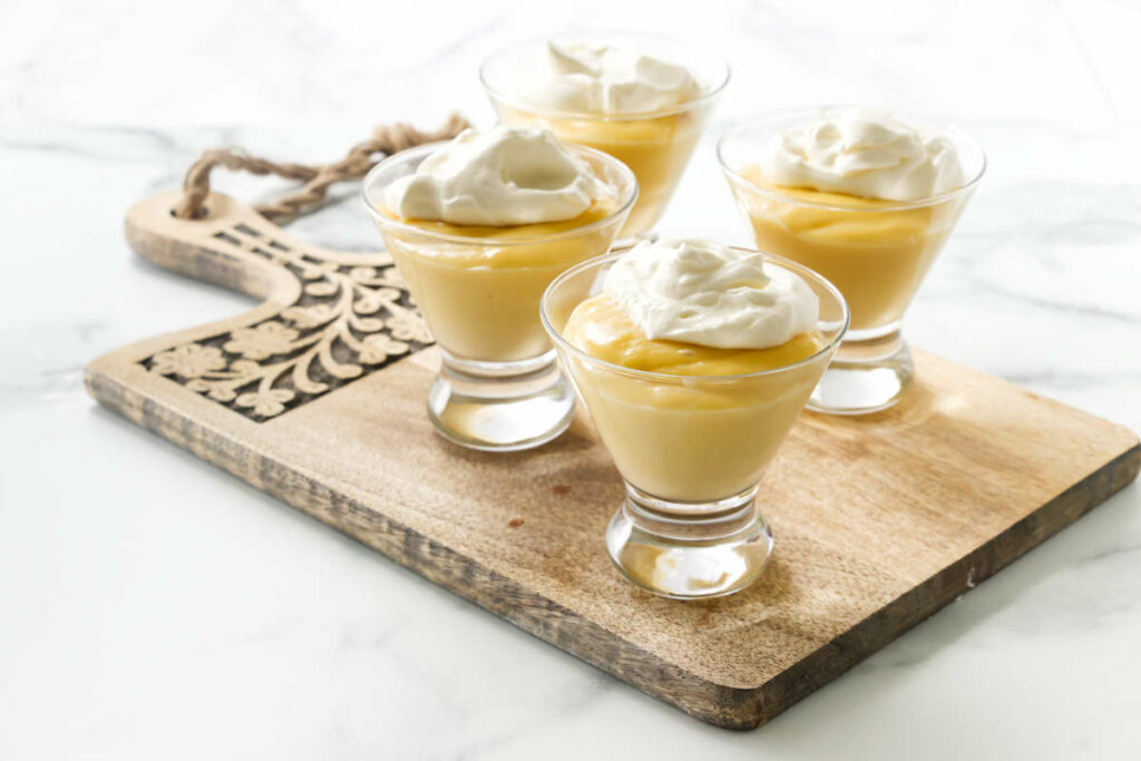 The best vanilla pudding recipe in glasses with whipped cream on top.