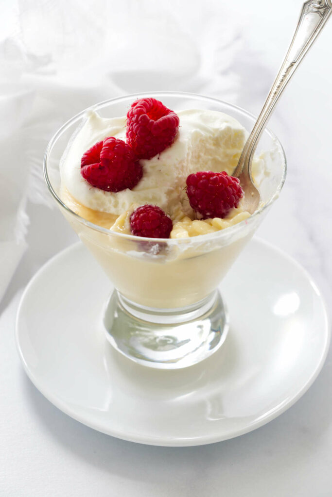 Easy cooked pudding in a dish with a spoon and whipped cream.