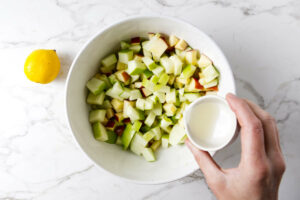 Tossing diced apples in lemon juice.