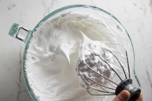 Whipping meringue to stiff peaks in a stand mixer.