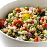 A white bean salad in a serving bowl.