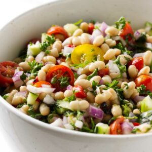 A white bean salad in a serving bowl.
