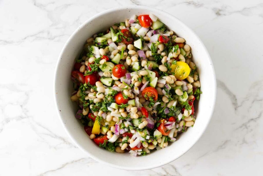 A white bean salad in a serving bowl.