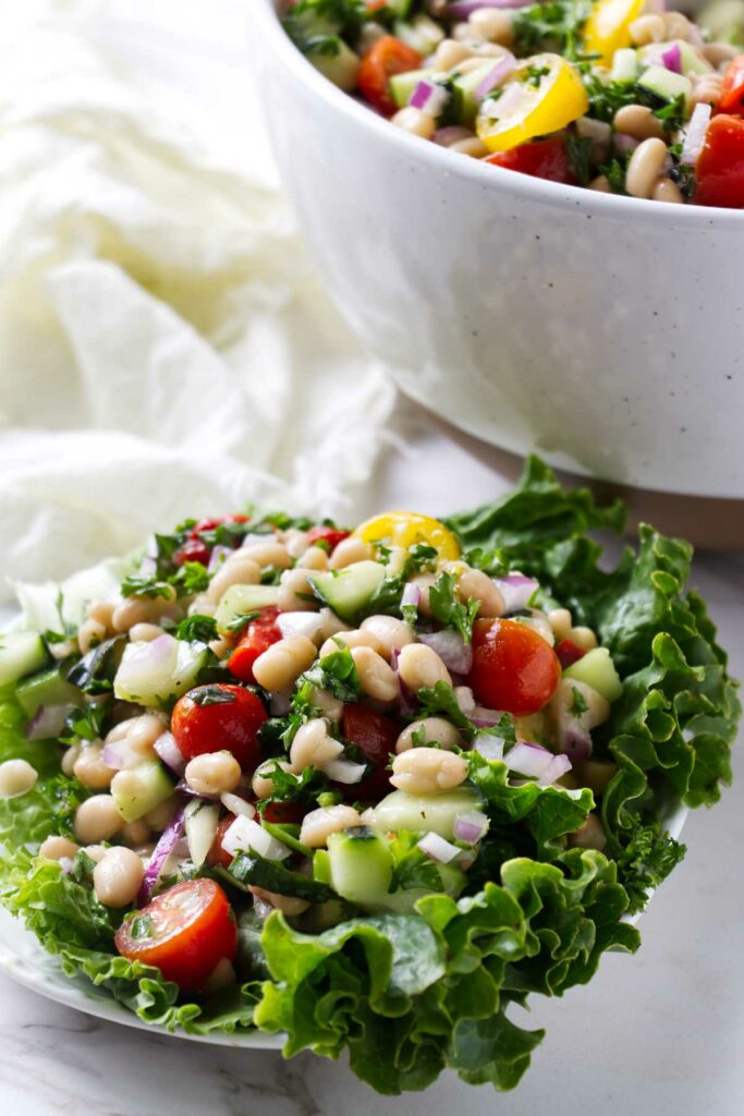 A white bean salad on a bed of lettuce.