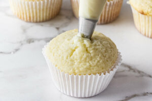 Filling cupcakes with white chocolate ganache.