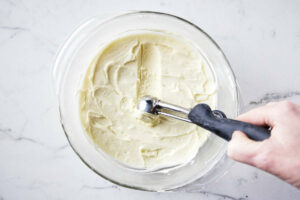 Scooping white chocolate ganache into balls to make truffles.