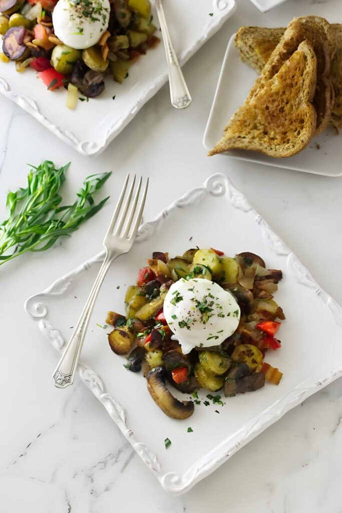 Sautéed vegetables with poached egg on plate, toast and herbs behind.
