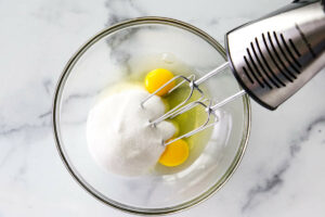 Eggs and sugar in a mixing bowl.