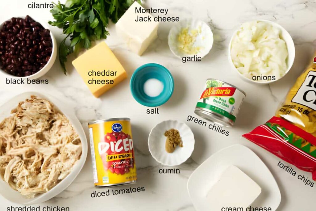 Ingredients for chicken nachos arranged neatly on a white surface.