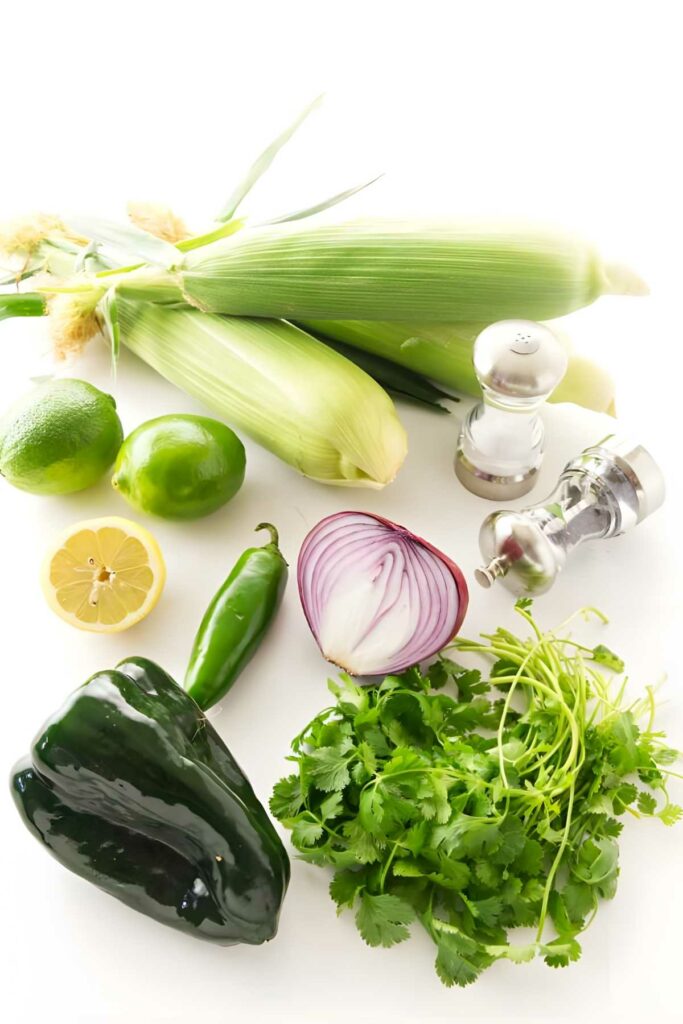 Fresh vegetables and seasonings arranged on a white background.