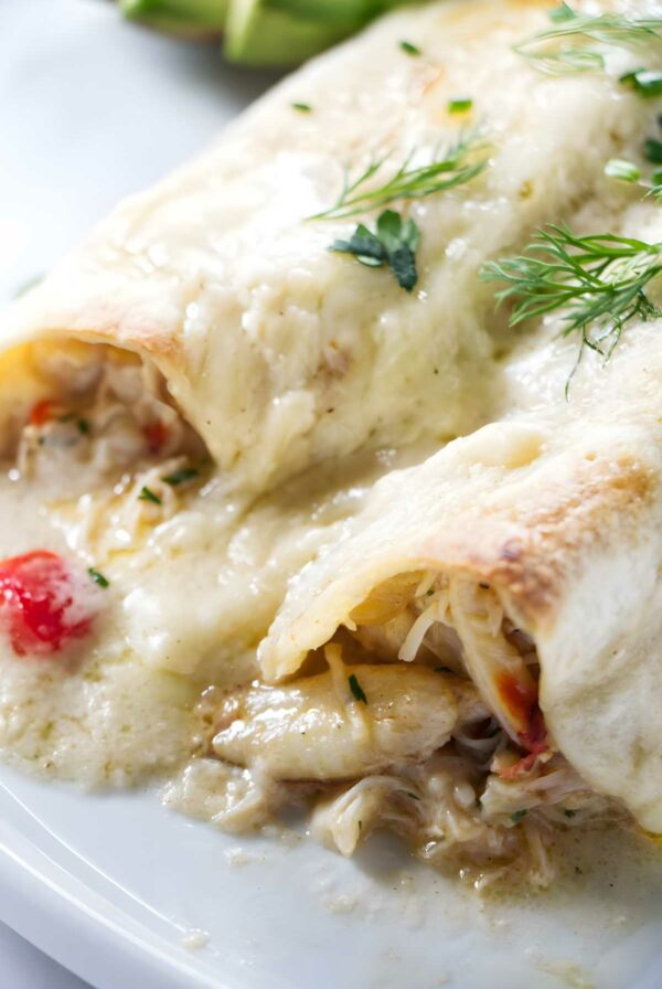 Cheesy crab enchiladas with creamy sauce, herbs, and red peppers.