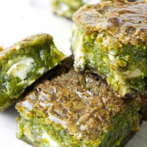 Three green matcha brownies with white chocolate chunks.
